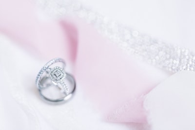 白色织物上的银钻石戒指